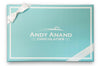 Blue box with white ribbon and 'Andy Anand Chocolatier' logo on a white background
