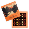 Chocolates in an open box with a scenic design on the lid, featuring the brand 'Andy Anand Chocolatier'.