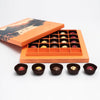 Open orange chocolate box with assorted chocolates on a white background