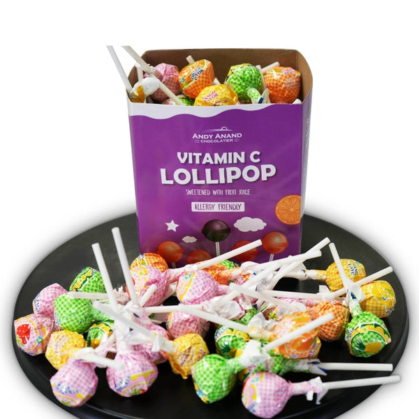 Colorful lollipops on sticks with a box labeled 'Vitamin C Lollipop' by Andy Anand Chocolatier.