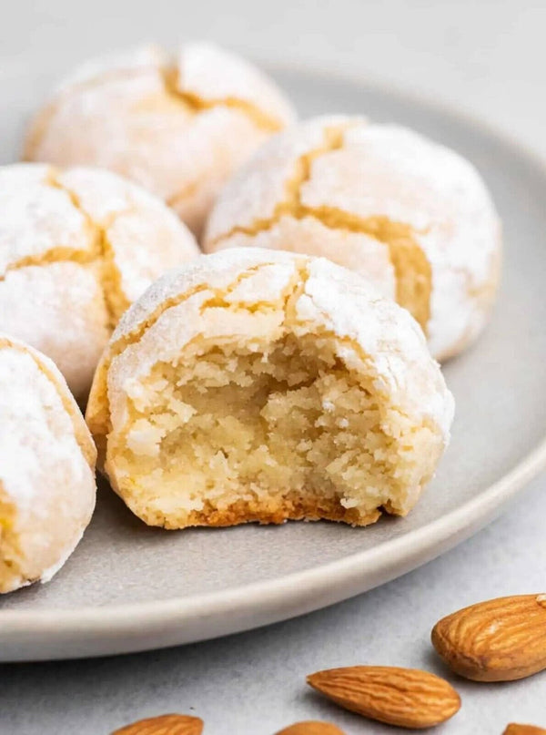 Glazed cookies on a plate with almonds on a light background