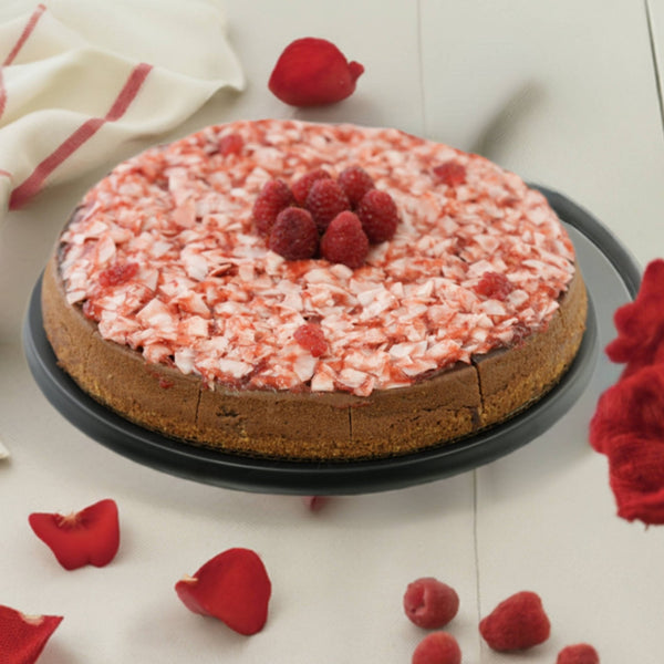Chocolate cake with raspberry frosting on a white surface