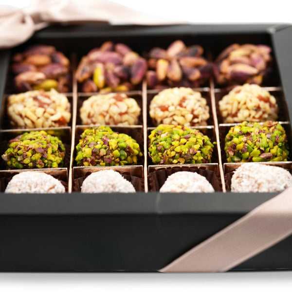 Individual sugar-free date truffles coated in crushed pistachio and toasted coconut on display