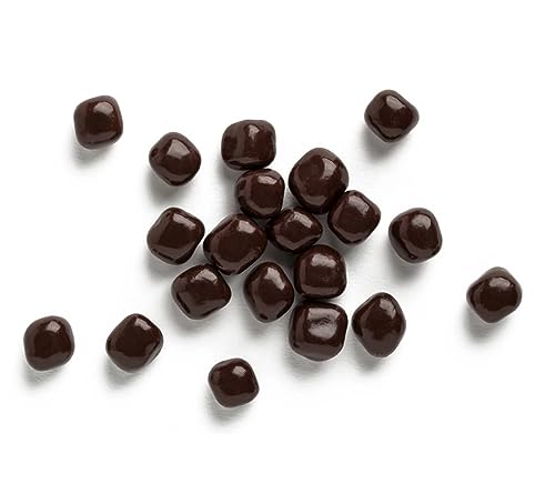 Dark chocolate buttons scattered on a white background