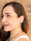 Close-up of green onyx and brass stud earrings worn on model's ear, Fair Anita