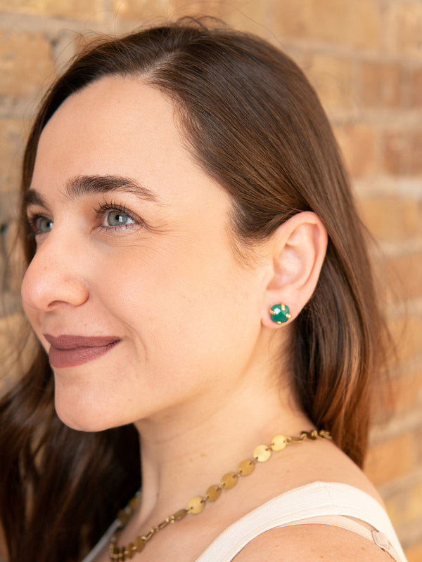 Close-up of green onyx and brass stud earrings worn on model's ear, Fair Anita