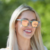 Close-up of AquaWave wooden sunglasses showing abalone shell detail on maple wood frame