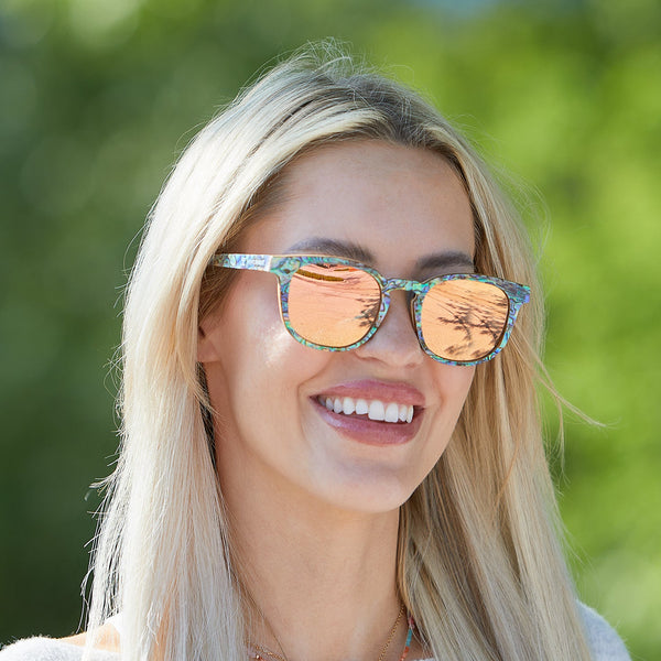 Close-up of AquaWave wooden sunglasses showing abalone shell detail on maple wood frame