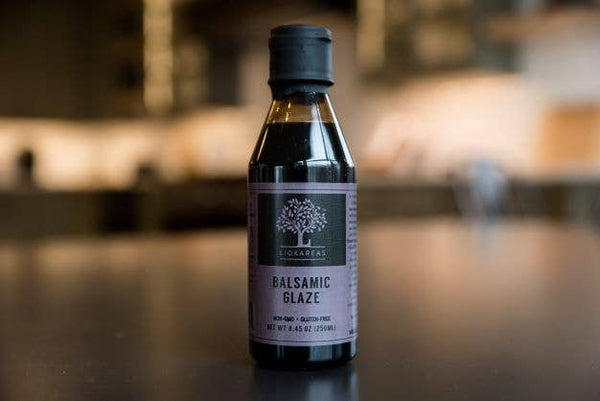 Bottle of Lichens Balsamic Glaze on a wooden surface with a blurred background