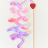 Decorative ribbon with a heart shape on a stick against a light background