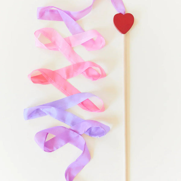 Decorative ribbon with a heart shape on a stick against a light background
