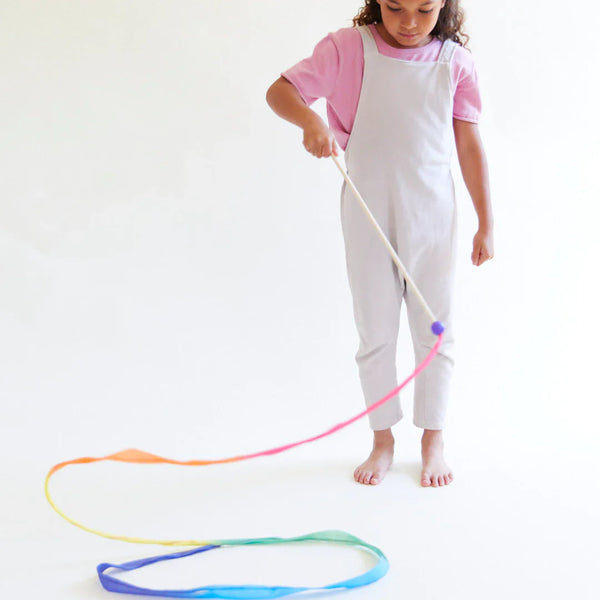 Child playing with a colorful jump rope on a white background