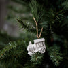 White train ornament hanging on a green Christmas tree