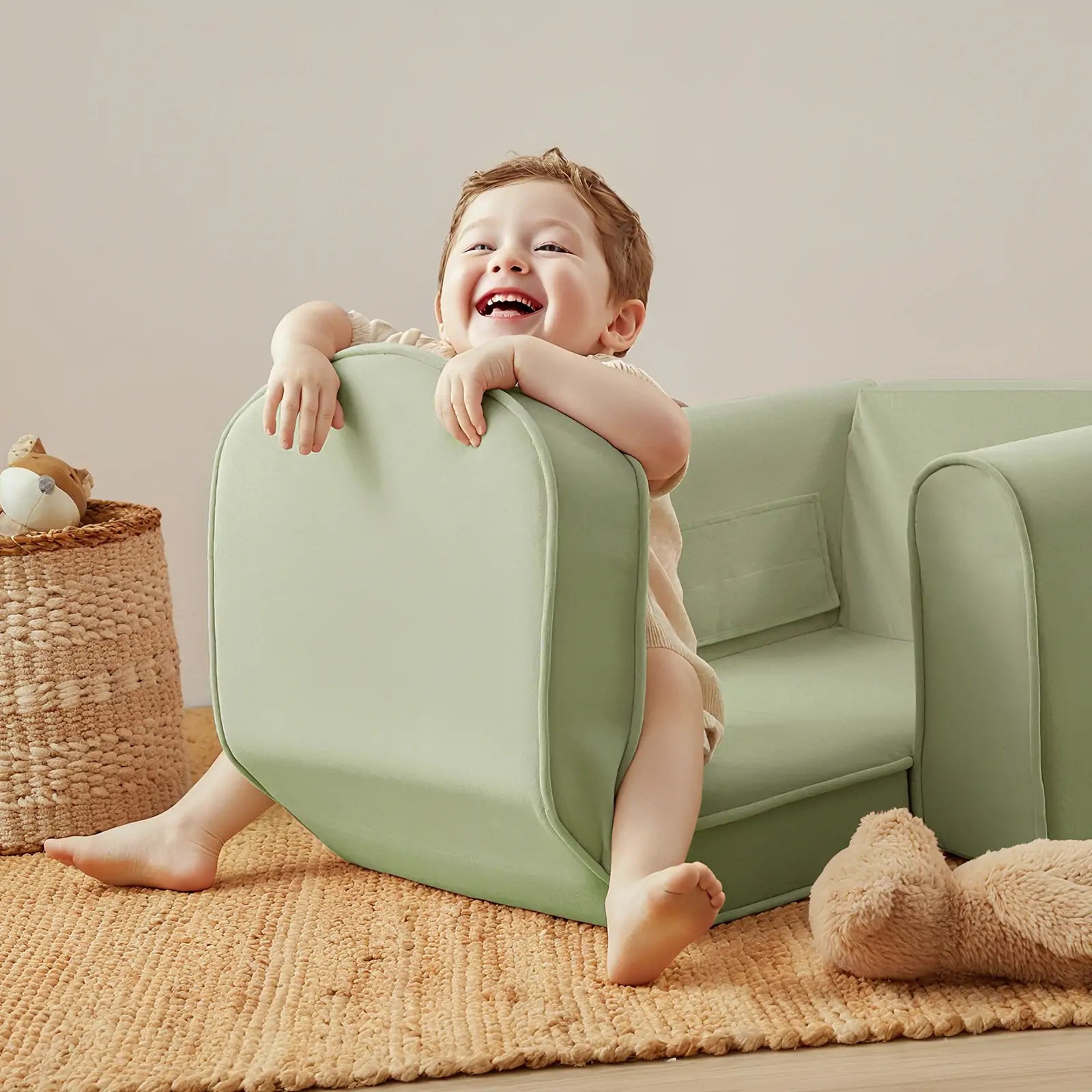 Child playing with a green cushion on a couch in a cozy room.