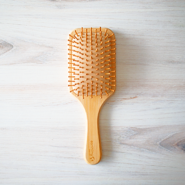 Wooden hairbrush on a light wooden surface