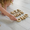 Child playing with bamboo alphabet learning toy, exploring letter shapes and spelling