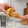 Bamboo Lemon Juicer being used to juice a lemon half