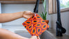 Washing a beeswax wrap with the Purple Papaya print with mild soap and water