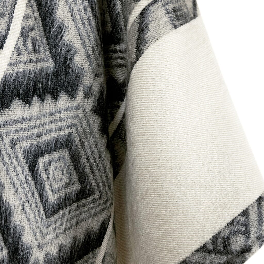 Close-up of textured fabric with geometric pattern and plain white fabric.