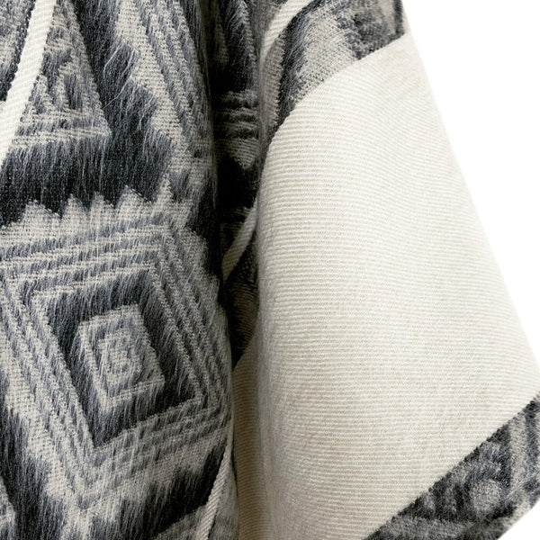 Close-up of textured fabric with geometric pattern and plain white fabric.