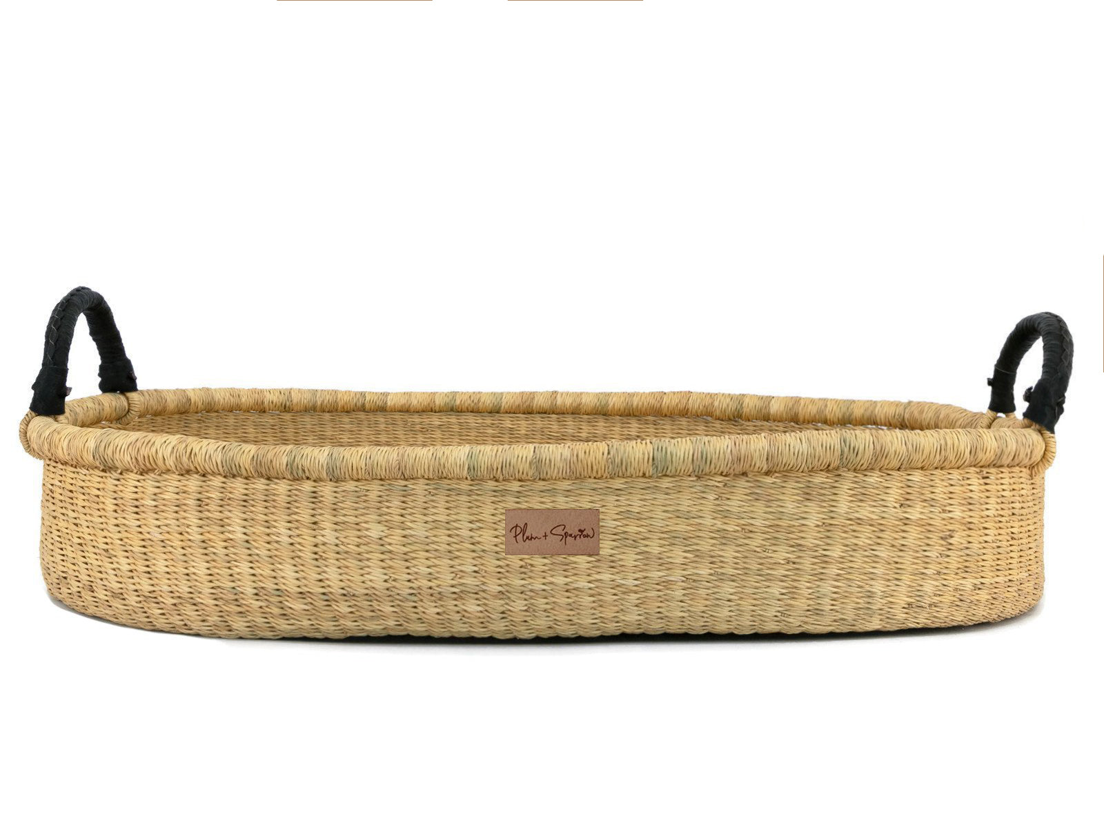 Woven basket with black handles on a white background
