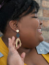 Model wearing Fair Anita black and gold arch statement earrings with casual outfit