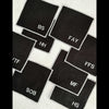 Close-up of black linen sweary coaster showing bold white lettering representing swear word monograms for a cocktail bar