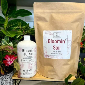 Elm Dirt Bloom Power Bundle — Bloomin' Soil 2 lb bag and Bloom Juice 32 oz microbial fertilizer bottle displayed together with flowering plants