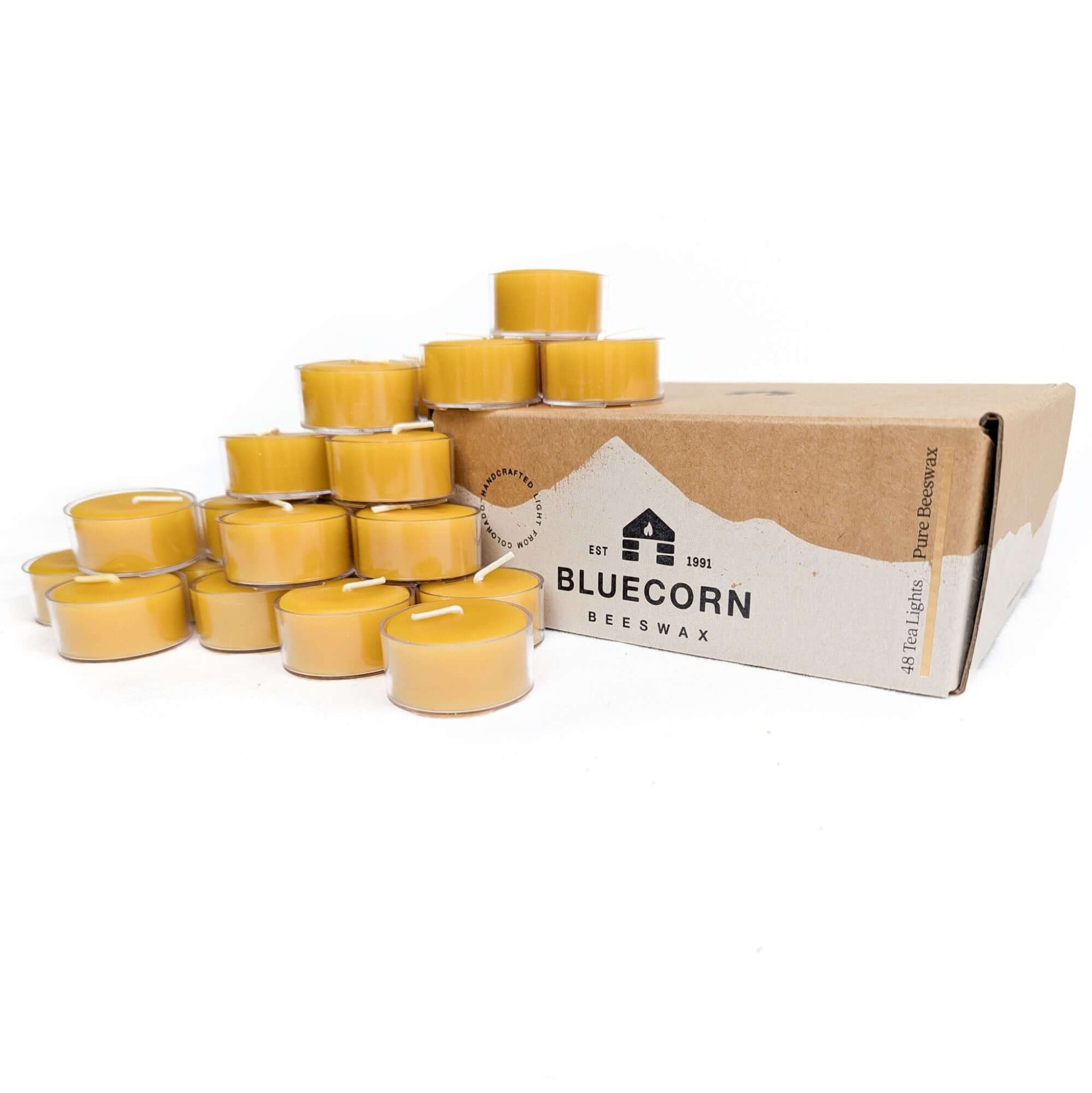 Beeswax candles in front of a Bluecorn Beeswax box on a white background