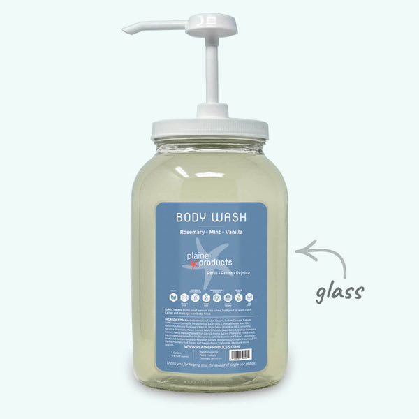 Glass body wash bottle with pump and blue label on a white background