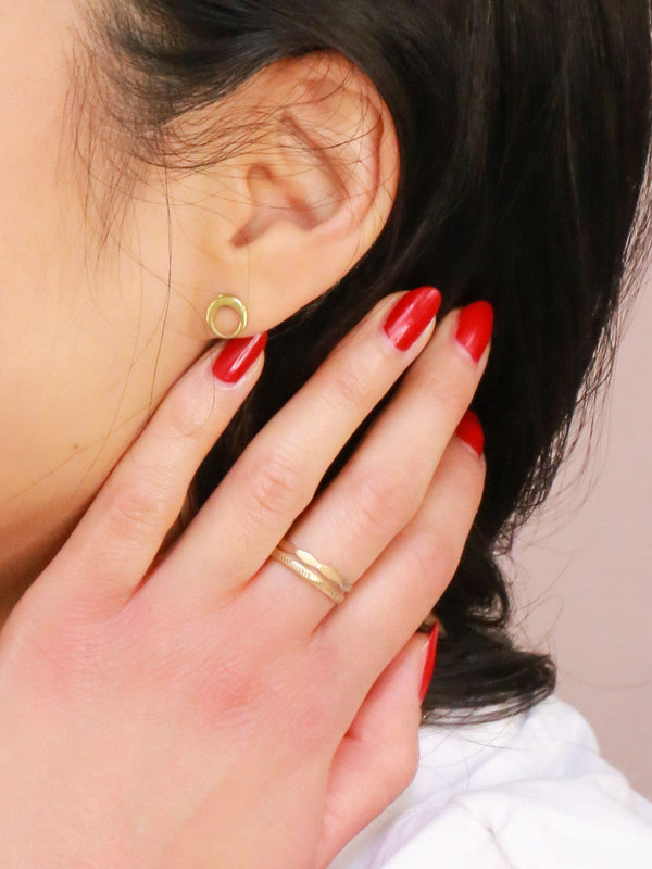 Brass stacking rings worn stacked on a finger showing golden colour and slim profile