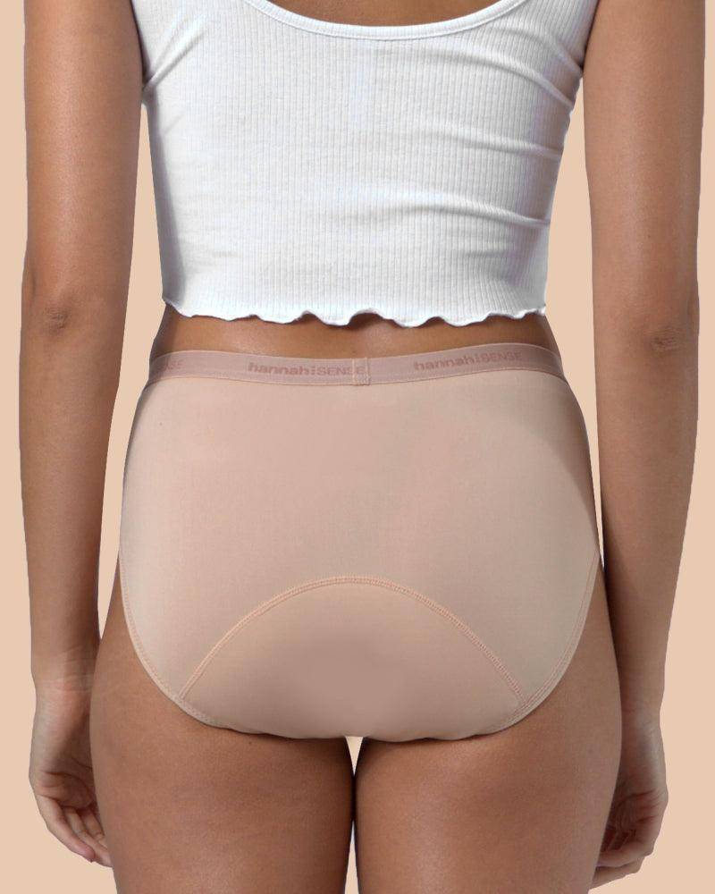 Person wearing beige underwear and a white crop top on a beige background