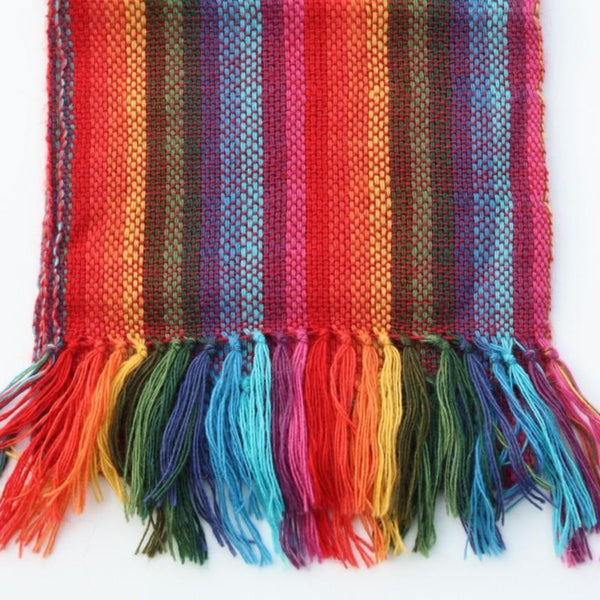 Multicolored woven scarf with tassels on a white background