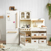 Children's play kitchen set with white cabinets, refrigerator, and oven against a white wall.