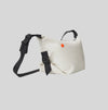 White bag with black straps on a light gray background. Shop the "Little Block" Crossbody Bag. Made from 14 recycled plastic bottles, this splash-resistant bag features a unique hemp texture and ample space for your essentials. The perfect sustainable gift for hands-free city living.