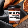 Jar of Fine & Raw chocolate hazelnut butter spread with bread on a wooden board.