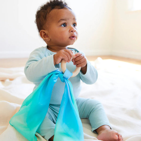 Sarah's Silks Sea Baby Teether with solid maple wood ring and ocean-coloured mini silk playsilk knotted onto it