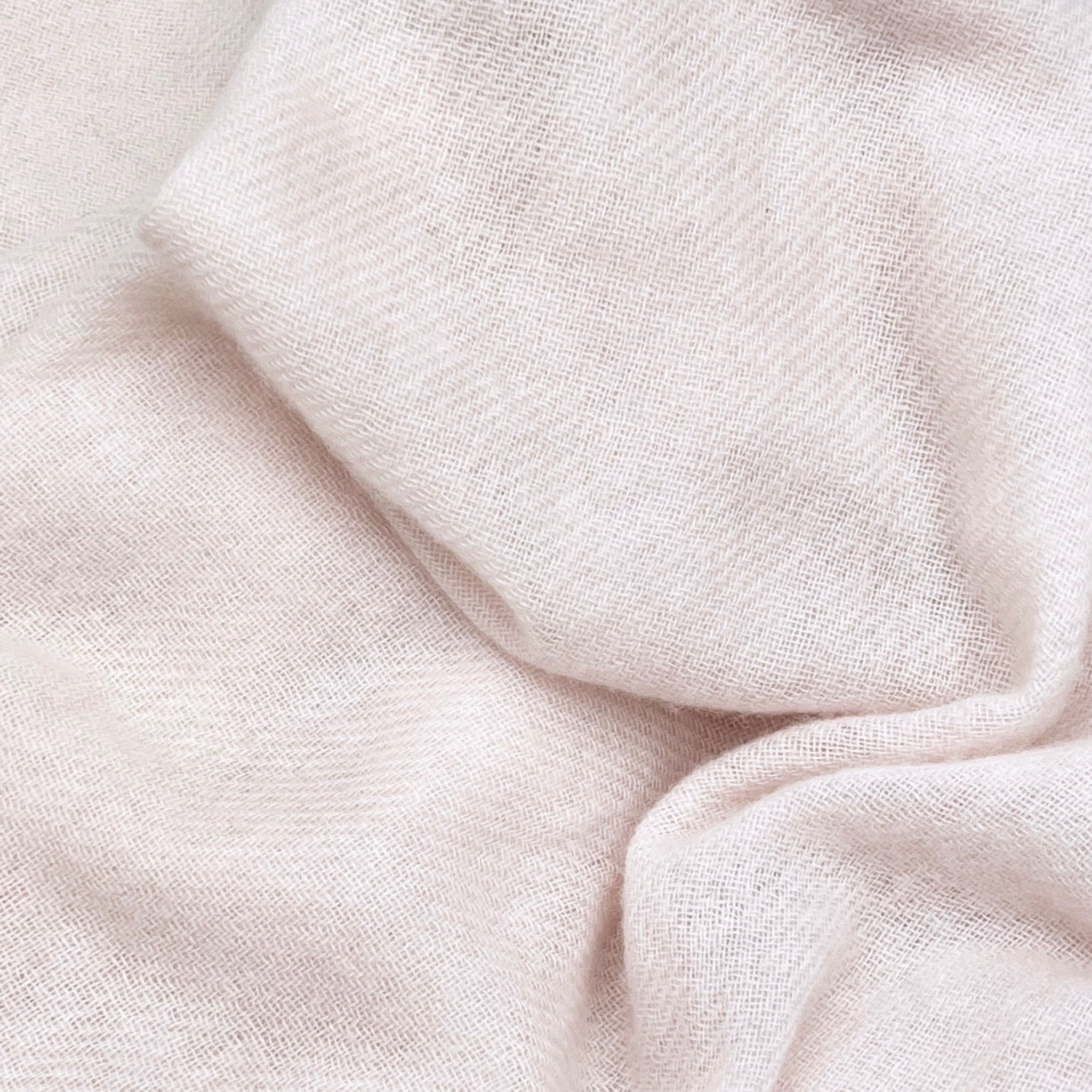 Close-up of light pink fabric with a soft texture