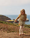 Young girl playing with a ribbon on a coastal cliffside
