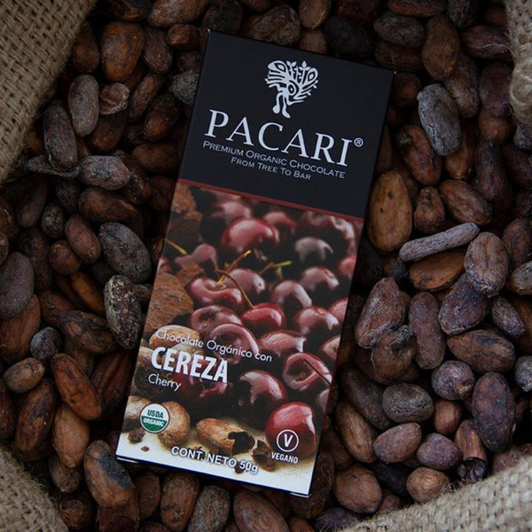 Pacari cherry chocolate bar packaging surrounded by cocoa beans