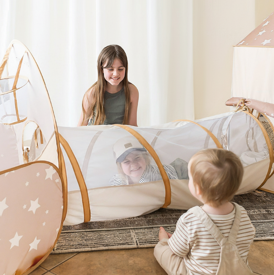 Children playing inside a star-patterned play tent in a home setting.