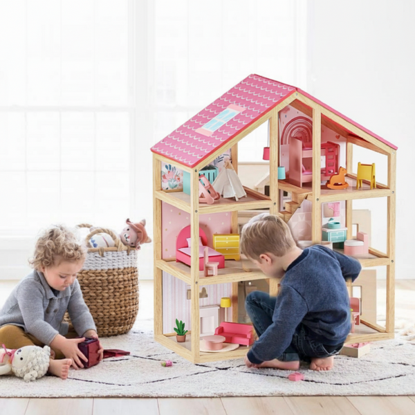 Two children playing with a wooden dollhouse on a light-colored floor.