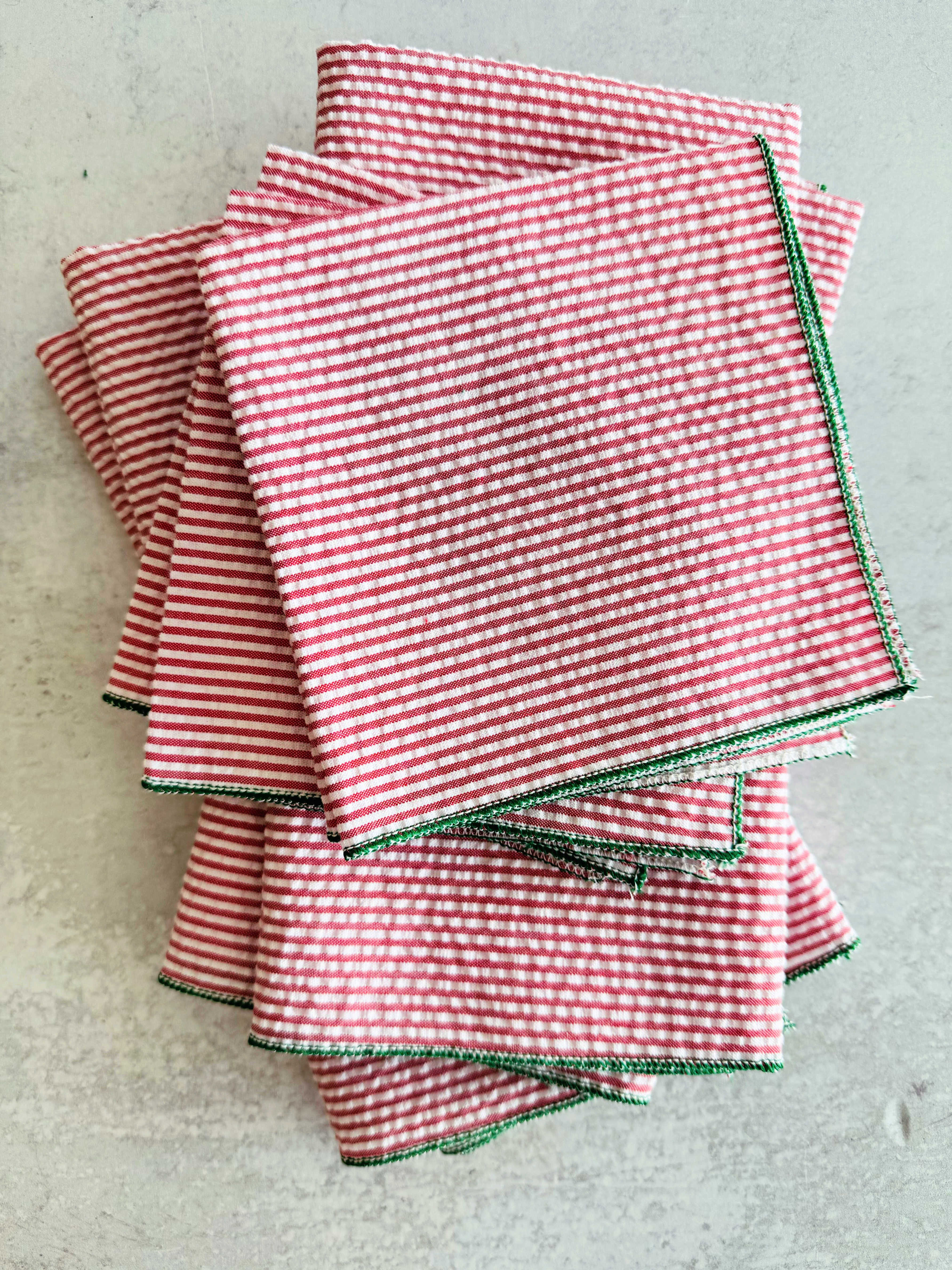 Close-up of red and green seersucker cloth napkins folded on a Christmas table setting