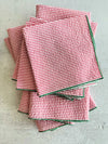 Close-up of red and green seersucker cloth napkins folded on a Christmas table setting