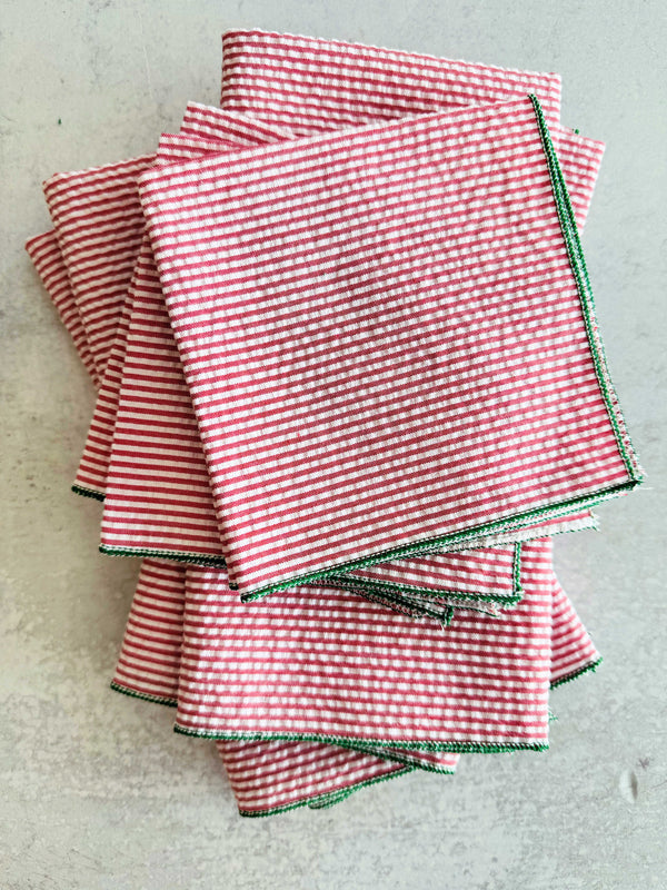 Close-up of red and green seersucker cloth napkins folded on a Christmas table setting