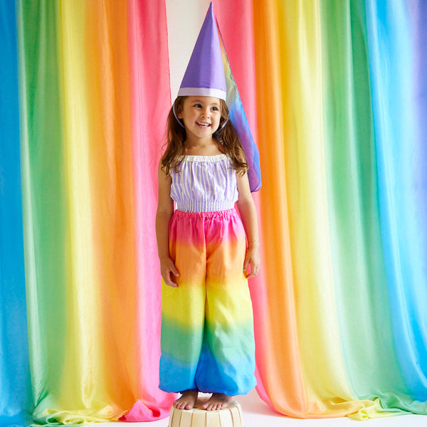 Unleash your child's inner jester with our Rainbow Jester Costume. This complete set includes a tunic, pants, and hat for endless fun and imaginative play. Perfect for parties, Halloween, and everyday adventures.