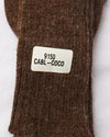 Brown textured fabric with a label on a white background. Classic Alpaca Socks – soft, breathable, and versatile for year-round wear. Ethically made in Peru. Shop timeless alpaca comfort today.