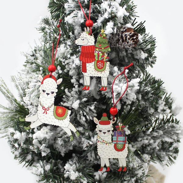 Decorative Christmas ornaments shaped like llamas on a snow-covered tree.