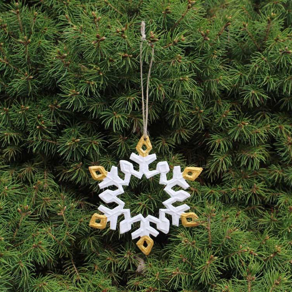 Decorative snowflake ornament hanging on a Christmas tree