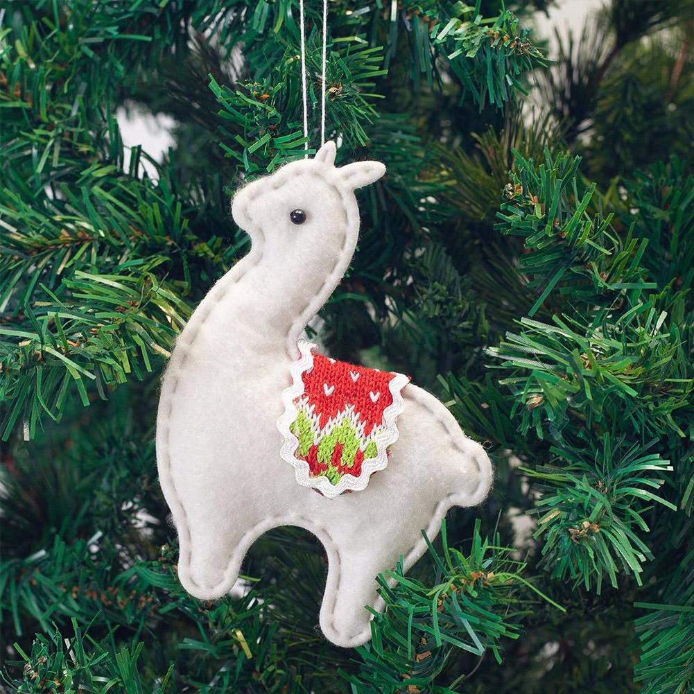 White llama ornament with red and green pattern hanging on a Christmas tree.